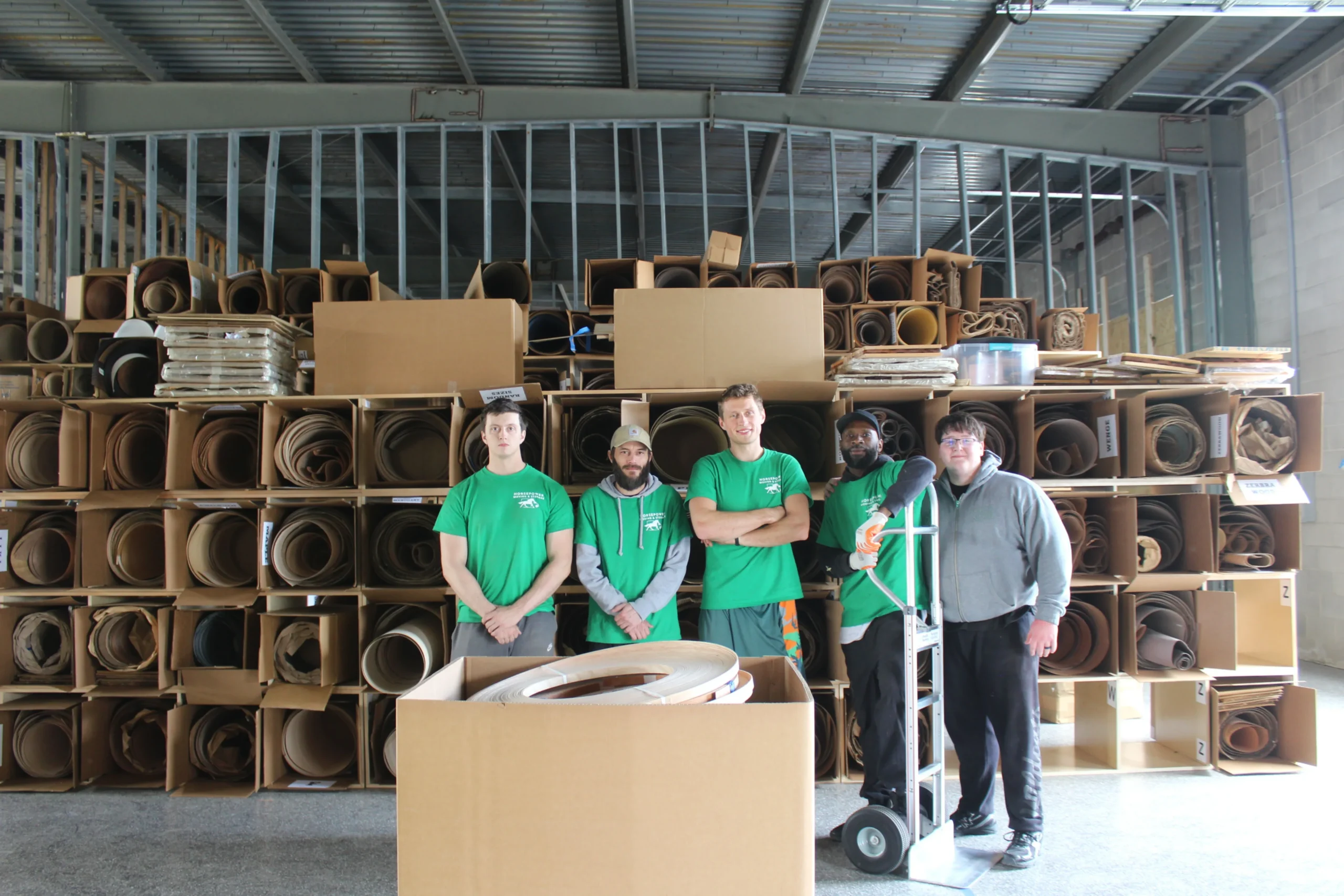 Horsepower Moving team inside a warehouse with stacked moving blankets and supplies in Louisville, KY.